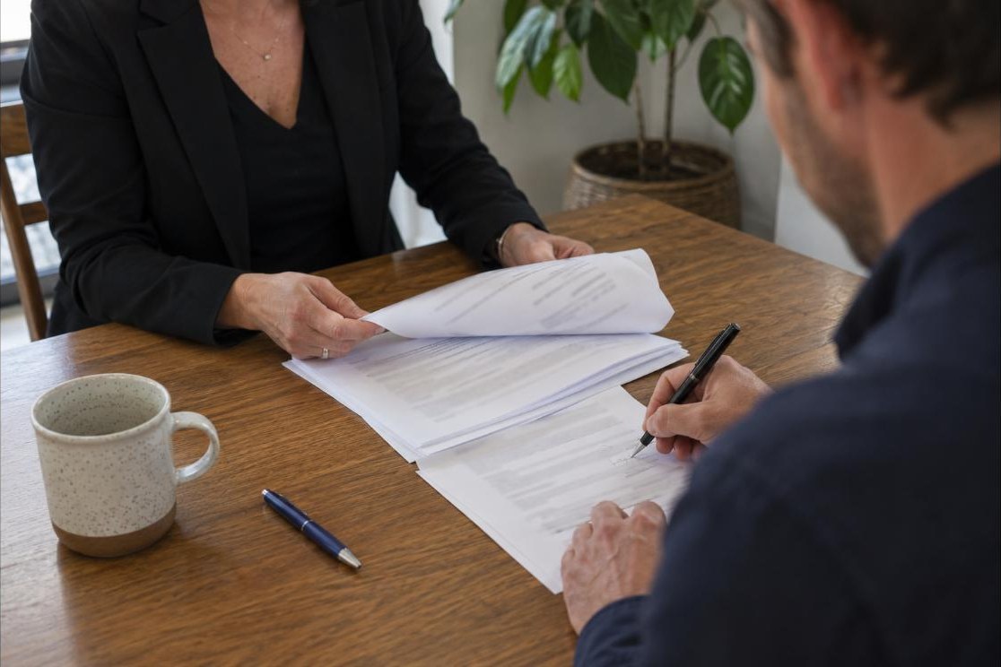 An offer being signed at a table
