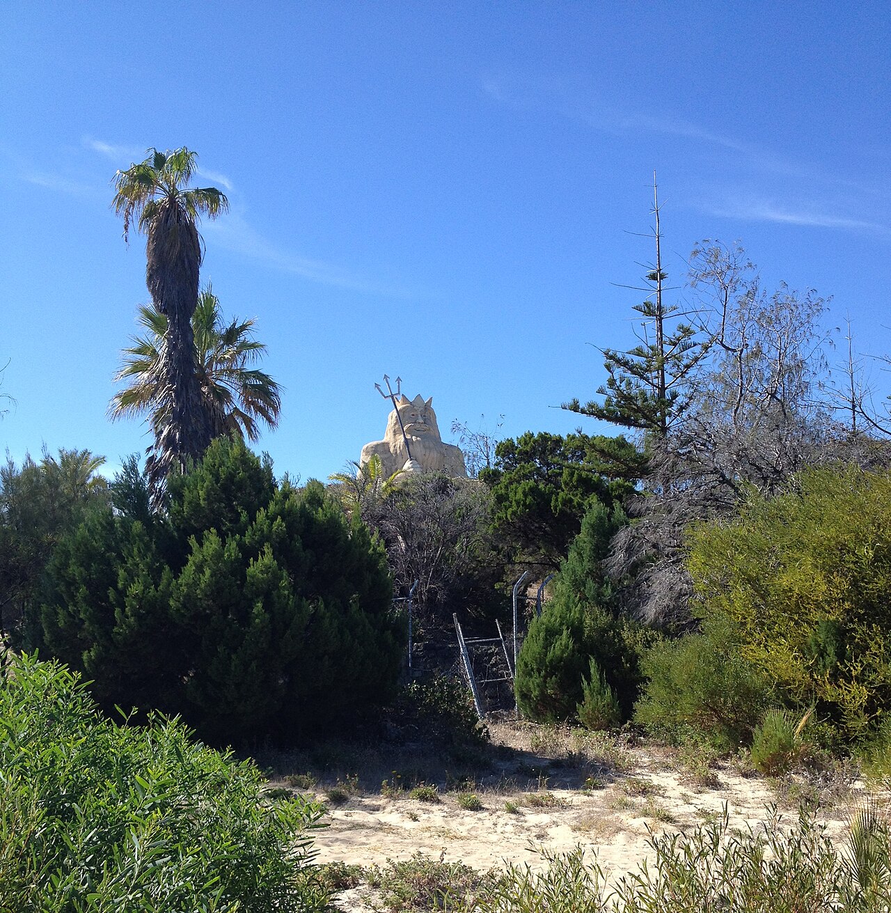 The King Neptune statue standing among palms at the former Atlantis Marine Park site, Two Rocks.
